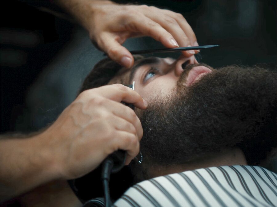 Barber shaping a beard at The Chair Barbershop in Chicago